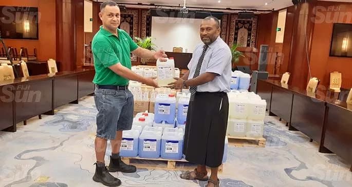 Fiji Chemicals representative presenting hygiene supplies to Fiji's health ministry