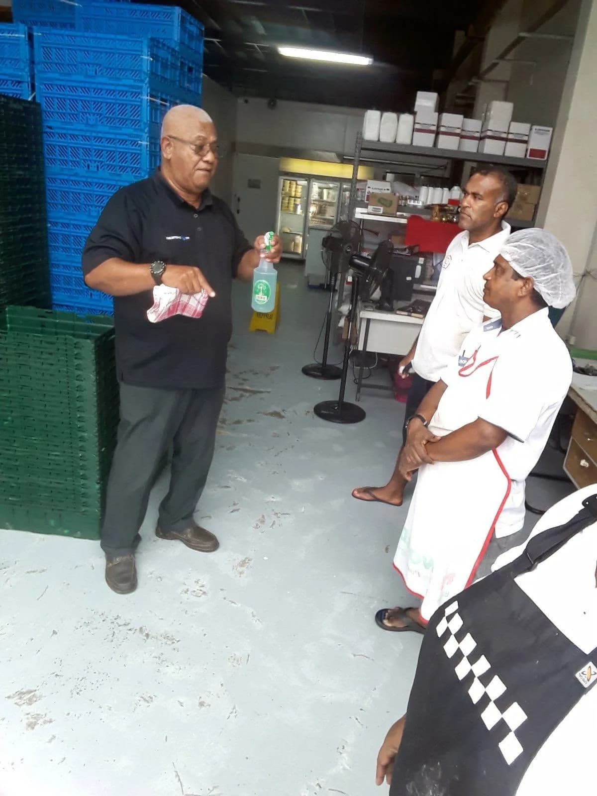 FCL trainer demonstrating a spray bottle to bakery staff