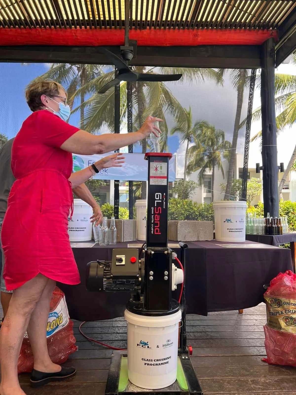 A glass bottle being fed into a crusher at the Hilton Fiji demonstration