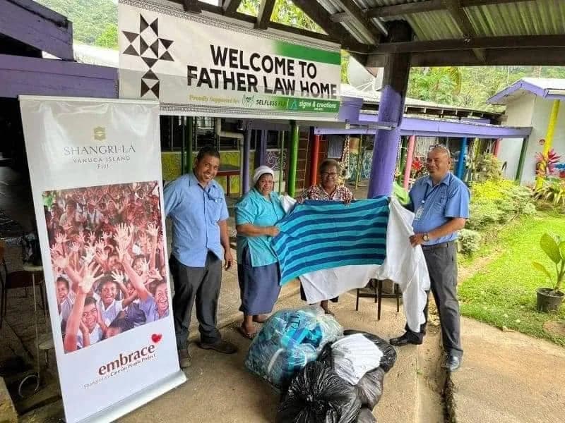 A linen handover outside Father Law Home