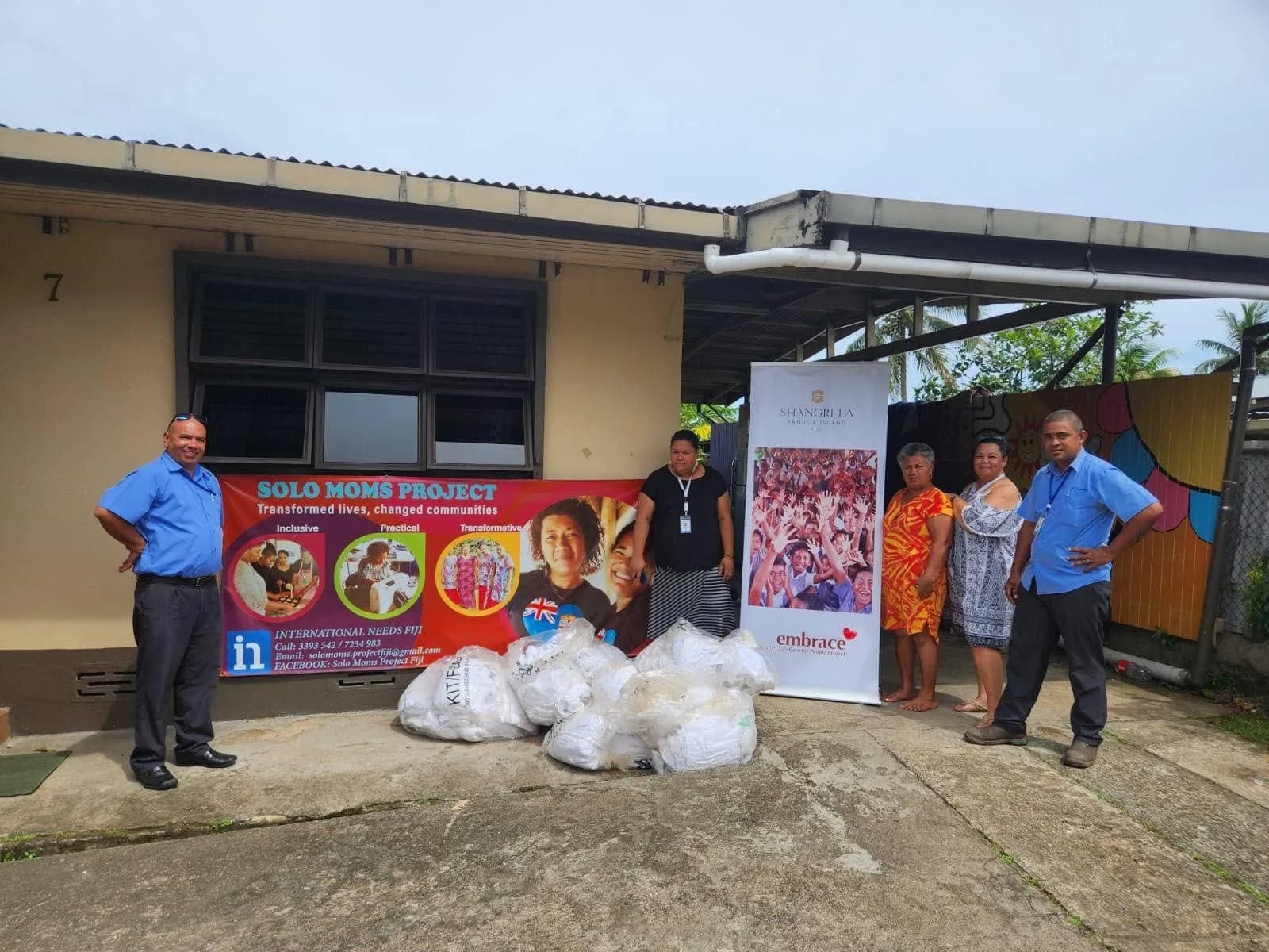 FCL and Solo Mums representatives with bags of donated linen