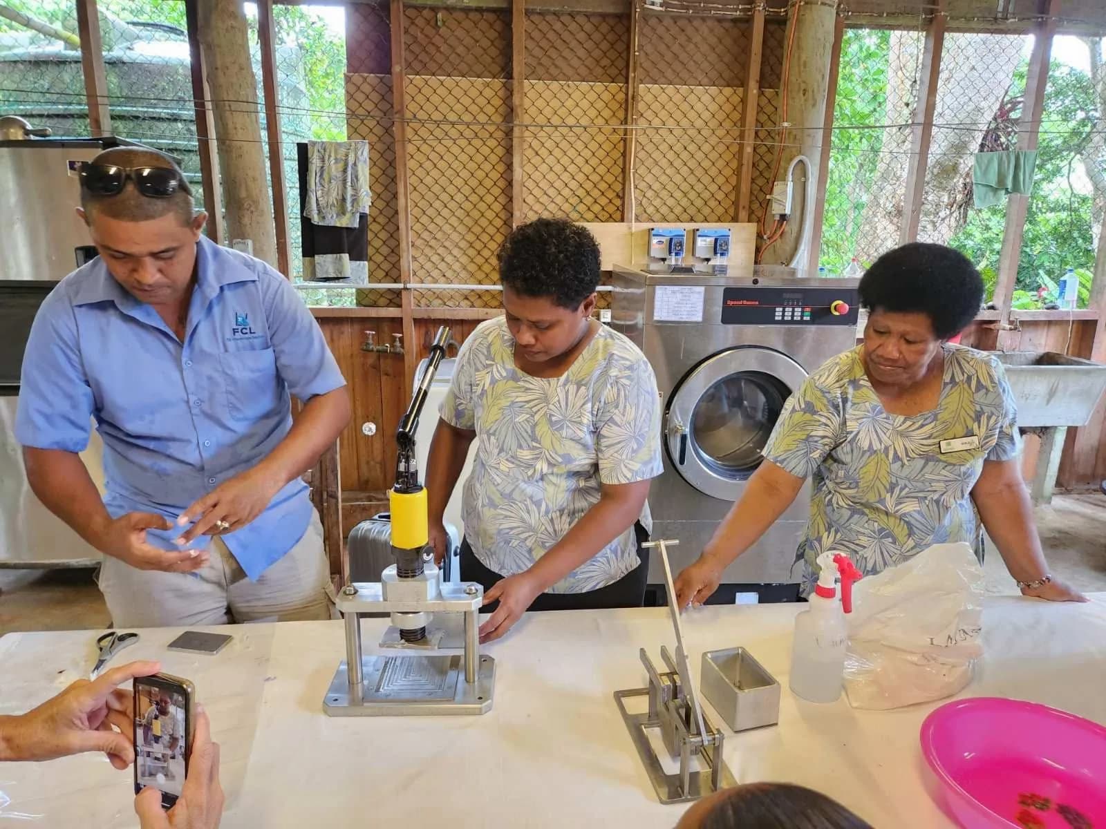FCL demonstrating a soap press with Namale Resort staff